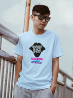 Person wearing a light blue t-shirt with a graphic design, standing outdoors.